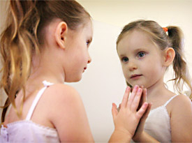 a child looking at themselves in the mirror.