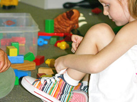 a child trying to tie a shoelace.