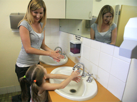 'A carer helping a child to wash her hands.