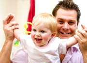 a baby playing safely with a carer.