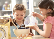 children in the kitchen mixing ingredients.