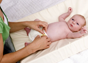 childcare worker changing a baby's nappy.