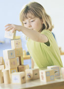 Picture of a child playing with wooden blocks.