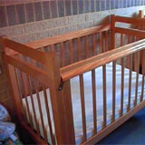 a cot bed with linen on it.