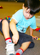 a child putting his socks on.