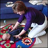 Woman approaching a baby lying on the floor