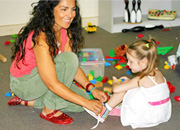 carer helping a child to tie her shoes.