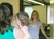 Picture of a childcare worker welcoming a family member and child when they arrive at the centre. ‘Hello, how are you?’